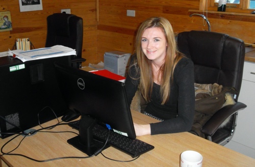 A person sitting at a table using a computer Description automatically generated